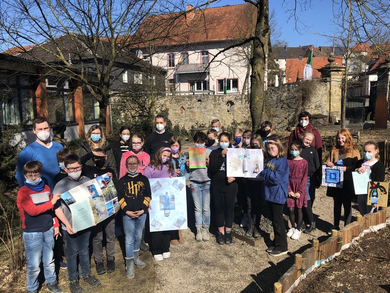 Stolz präsentieren die Schülerinnen und Schüler der Klasse 5b ihre Werke im Klostergarten der Schule.