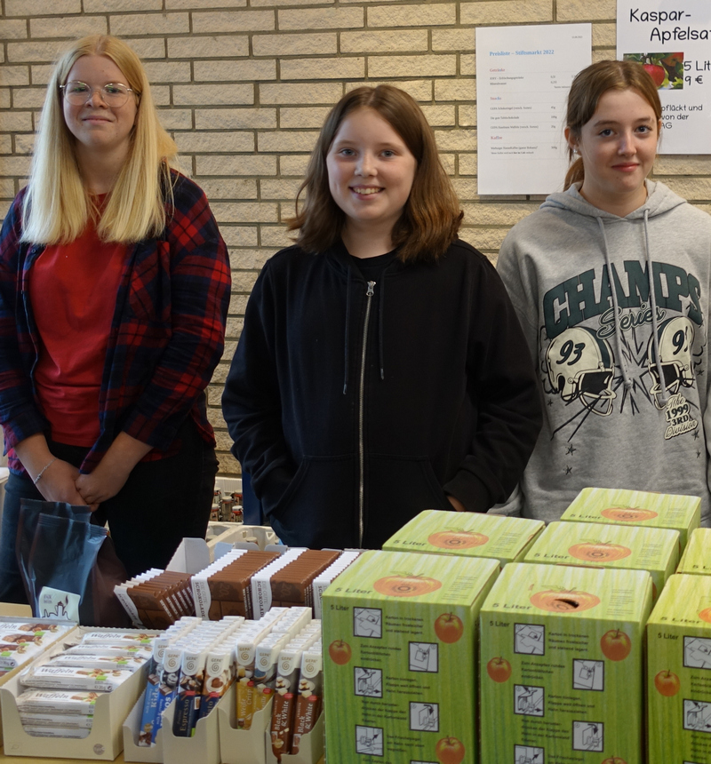 Sie verkaufen frisch gepressten Apfelsaft der Mit-Welt-AG und auch Leckereien der Schülergenossenschaft SNacK (v.l.): Lea Schopohl (Q1), Catharina Pohl und Laura Grün (beide 7b).